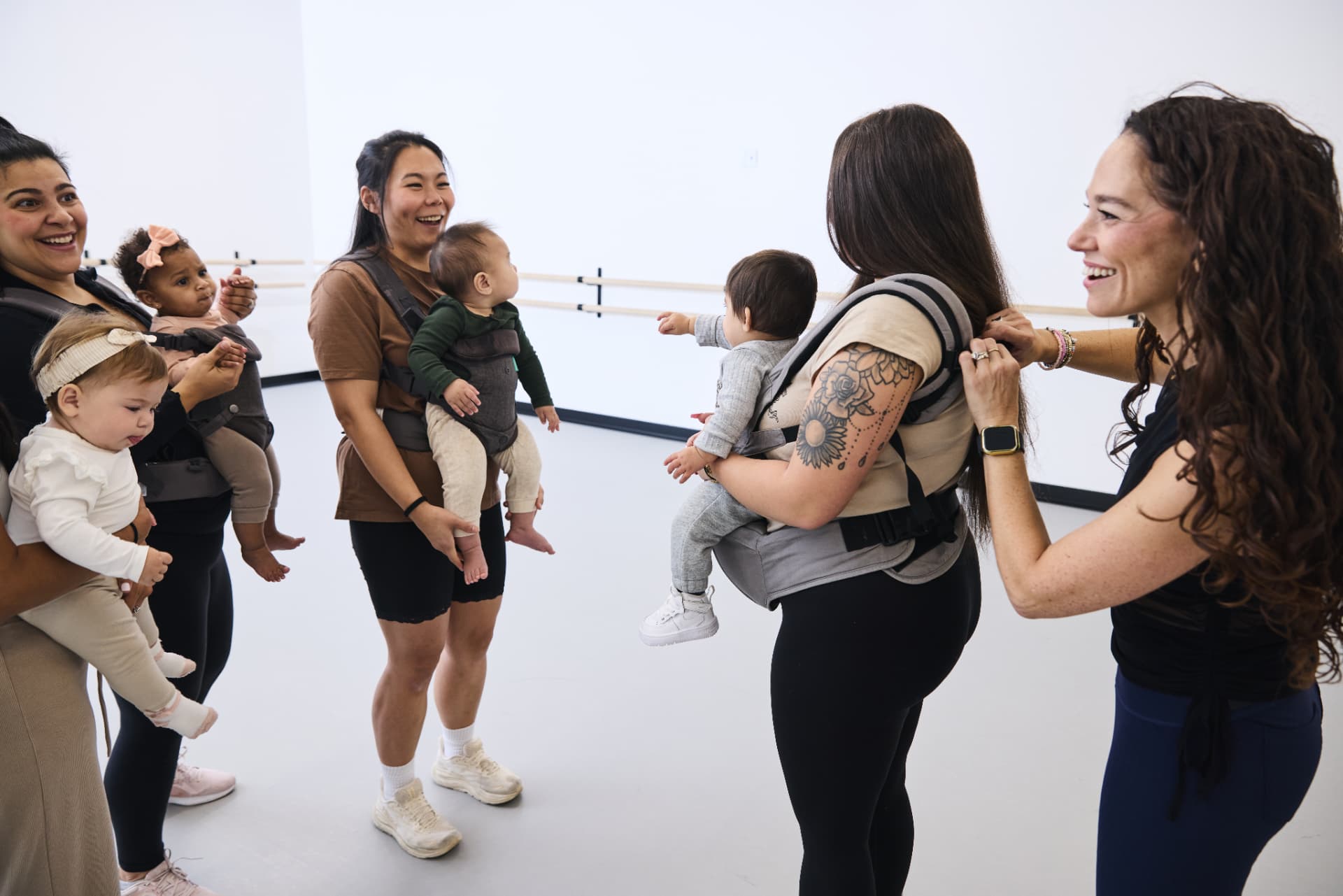 Moms chatting and laughing with their babies in the studio