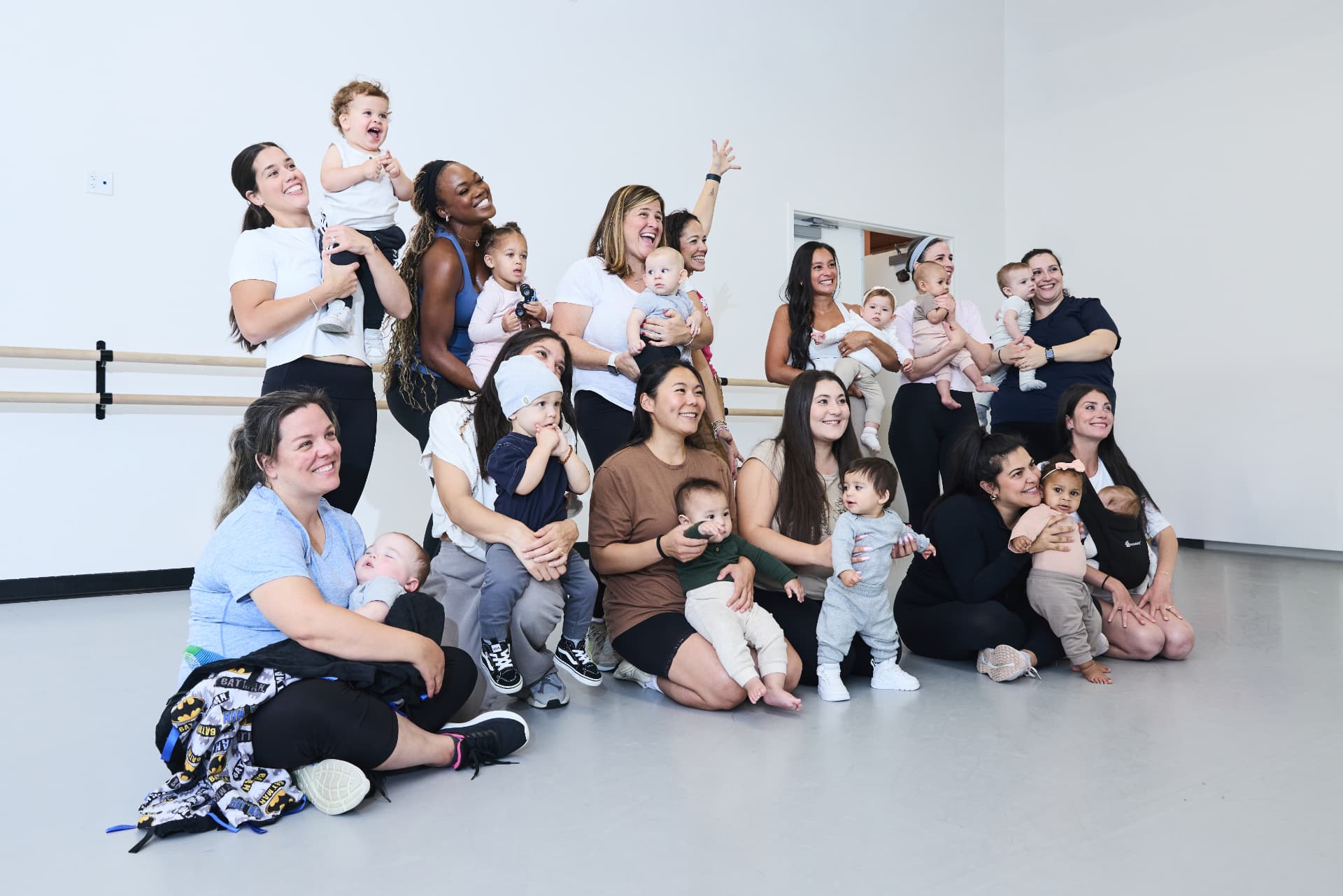 Boogie Babies moms and toddlers posing together, standing and sitting across the studio floor