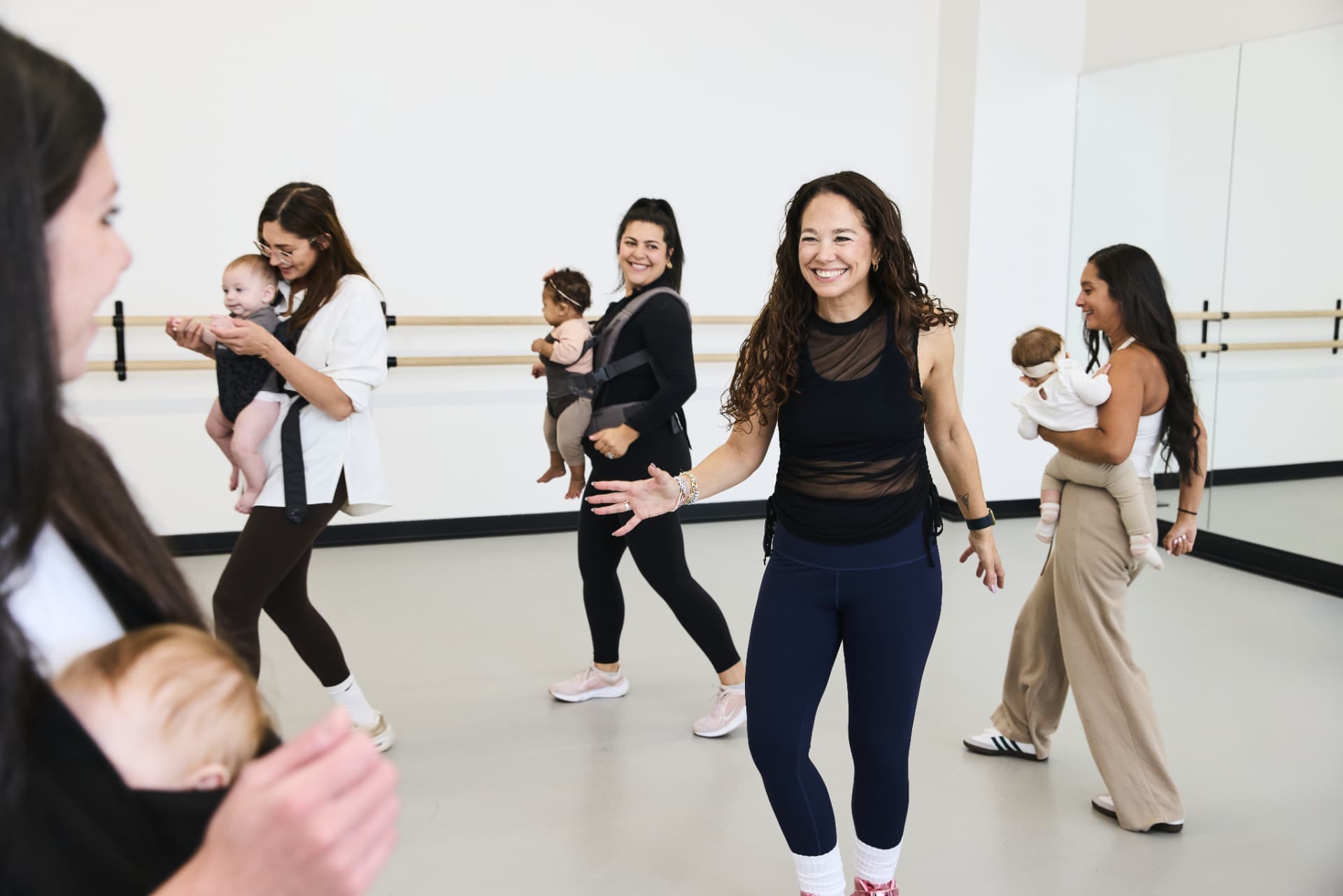 Deb and moms dancing together with their babies in the studio