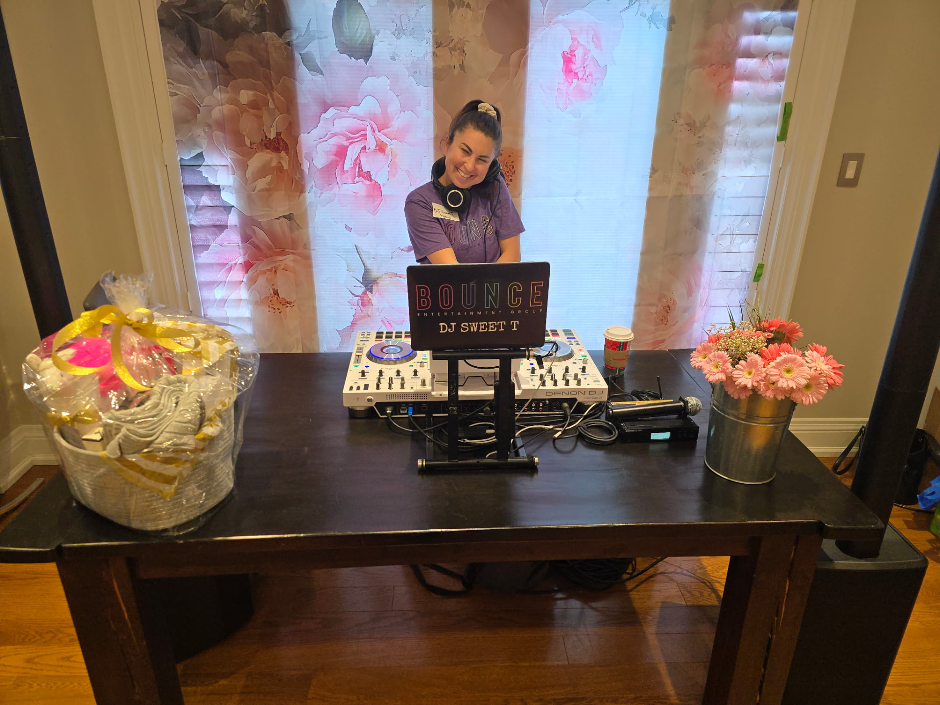 Smiling DJ in a purple t-shirt and headphones behind the mixer at Sweat and Sparkle